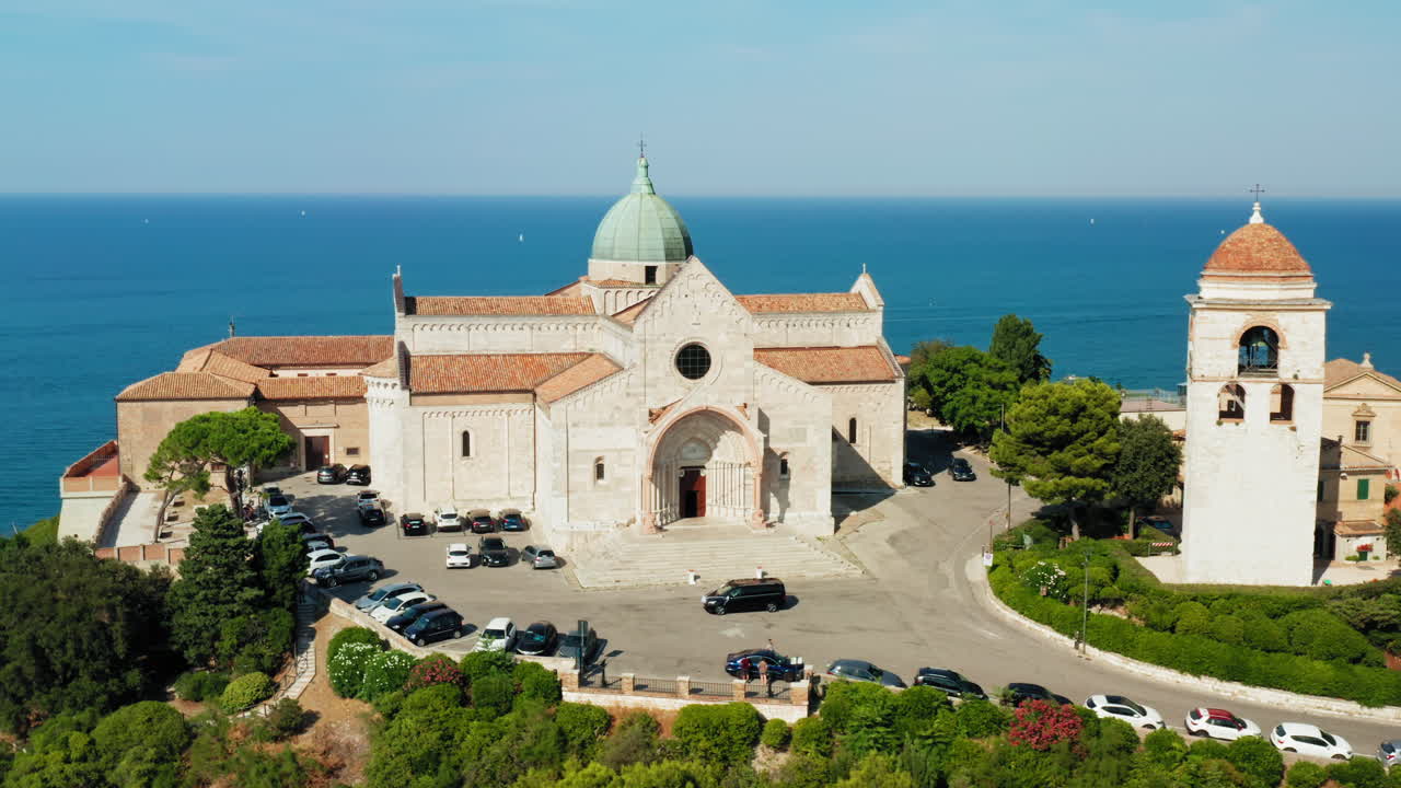 배경에서 아드리아 해가 내려다보이는 언덕 꼭대기에 위치한 유서 깊은 성 시리아코 성당의 영화적 전망