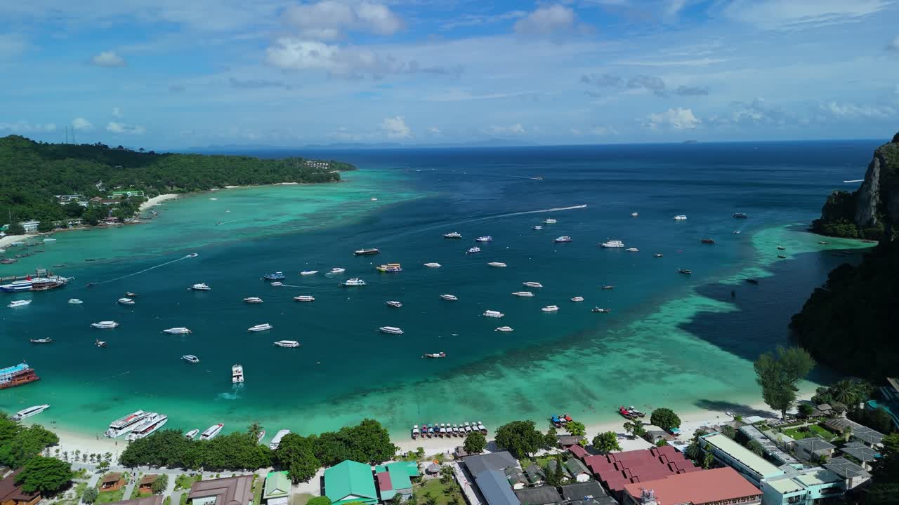 Drone ascends, pulling back to reveal Loh Dalum Beach and boats on Phi Phi Don