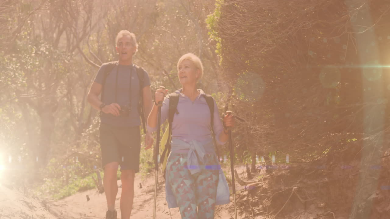 pareja de ancianos caucásicos en una caminata en el campo, sobre el destello de la lente y las luces de la ciudad bokeh