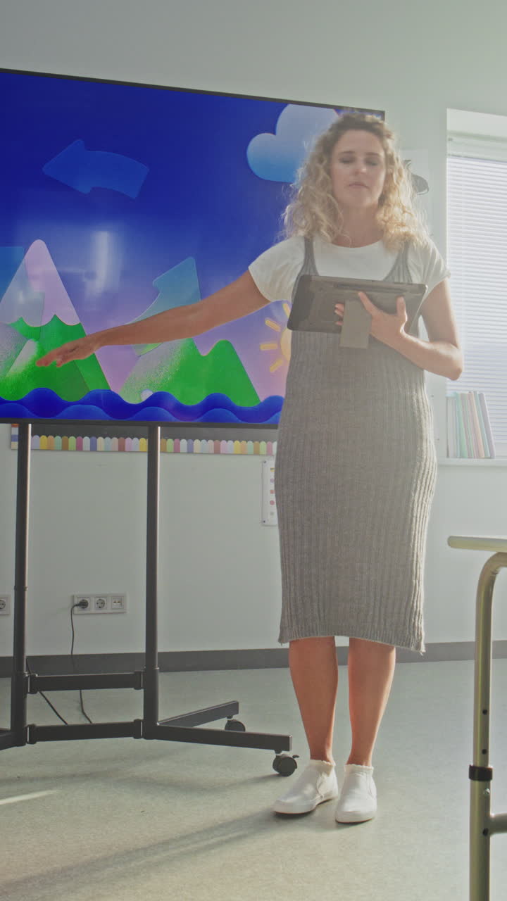 Female Teacher with Tablet Computer Explaining Water Cycles to Kids Using Digital Screen