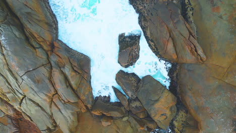 the ebb and flow of an outgoing tide against a rocky outcrop