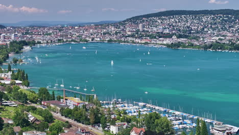 vista panorámica del lago de zúrich con barcos atracados a lo largo de la orilla en un día soleado