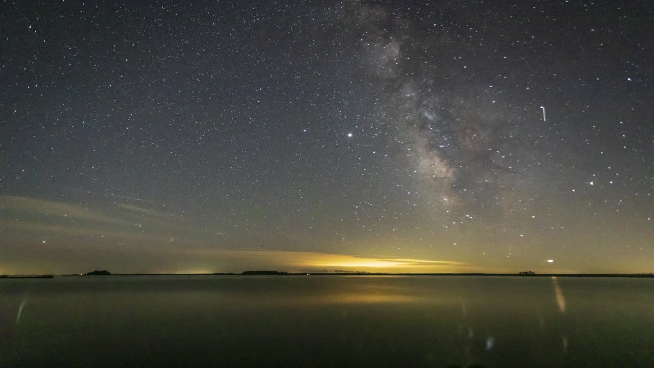 Day Turns To Night Time Lapse over Lake with Stars and Planes