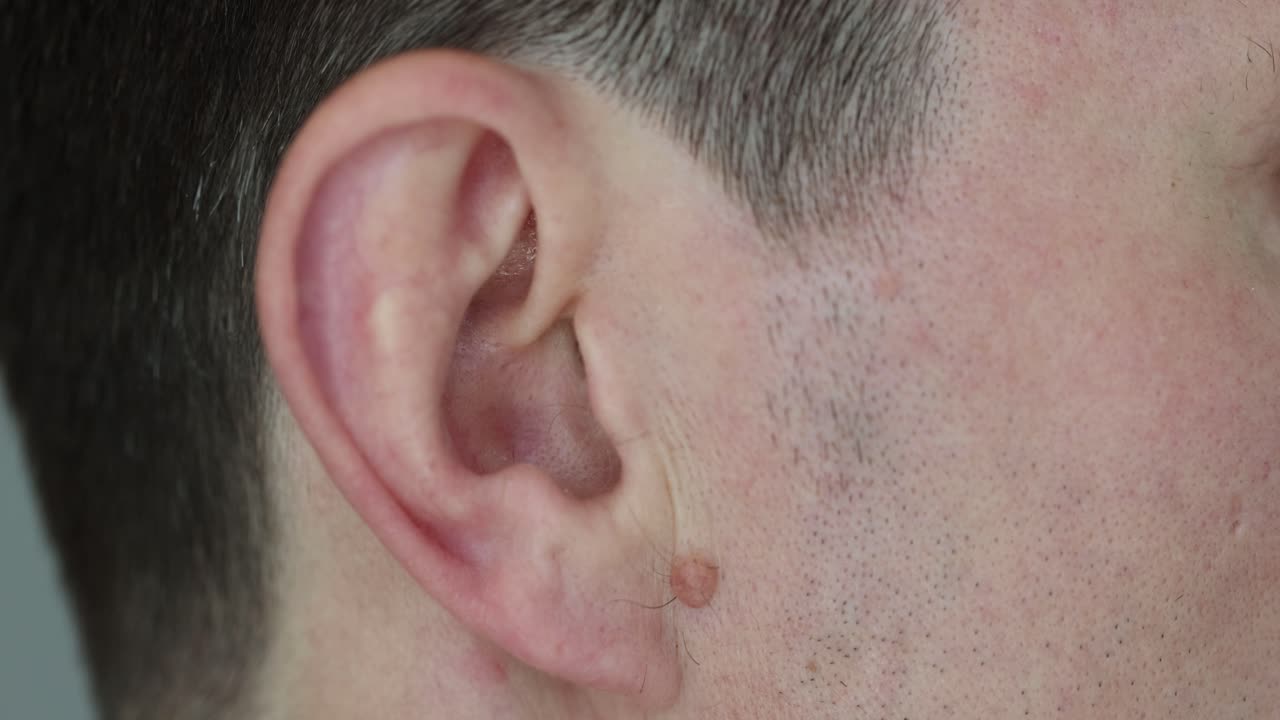 Close-up of a man's ear and face