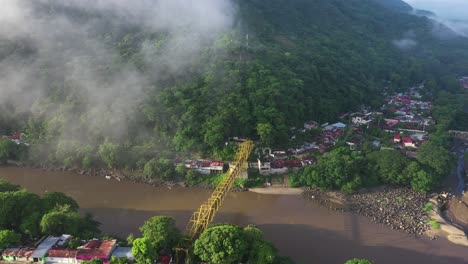 drone aerial view of honda, tolima, colombia, clouds above valley and bridge on magdalena river on sunny day