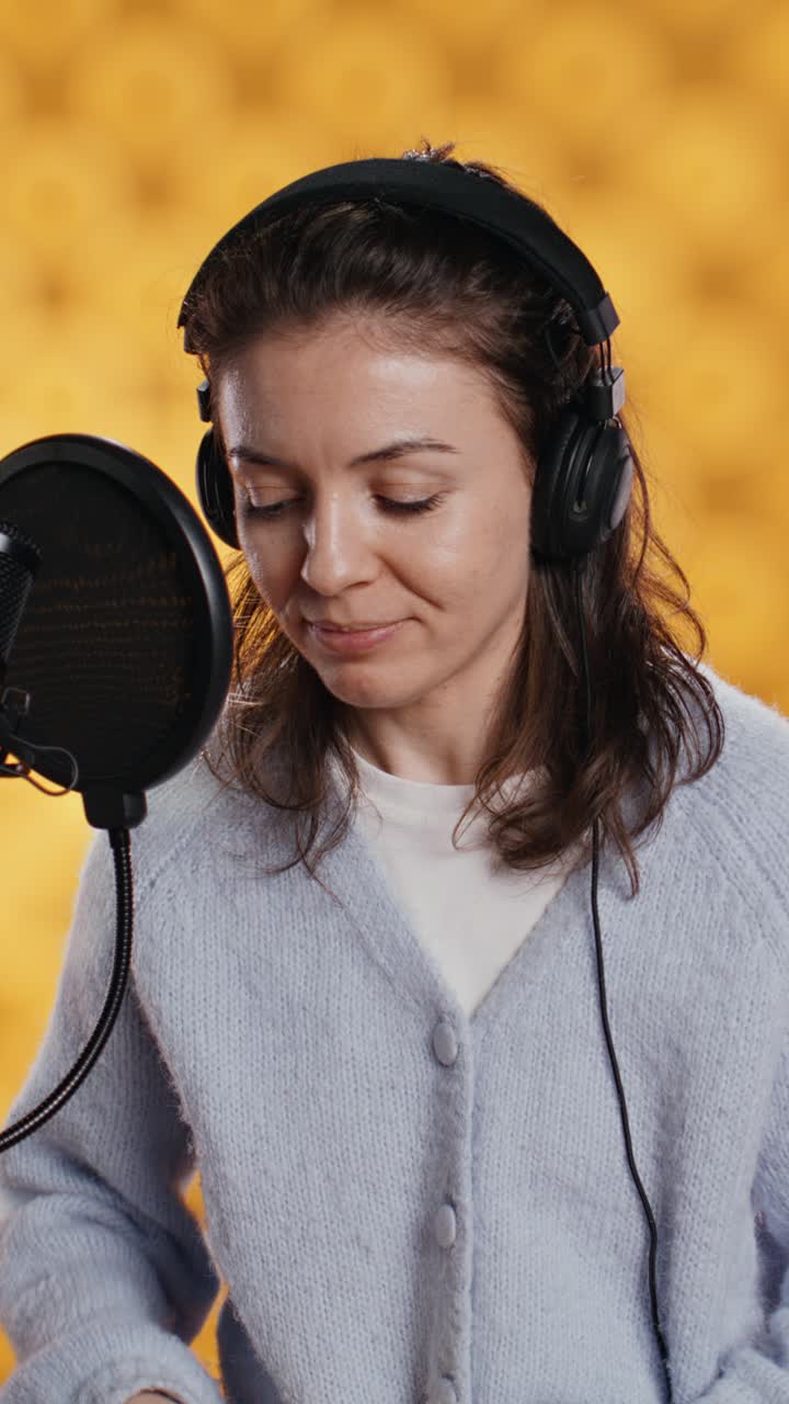 Donna che registra un audiolibro in studio con microfono e cuffie