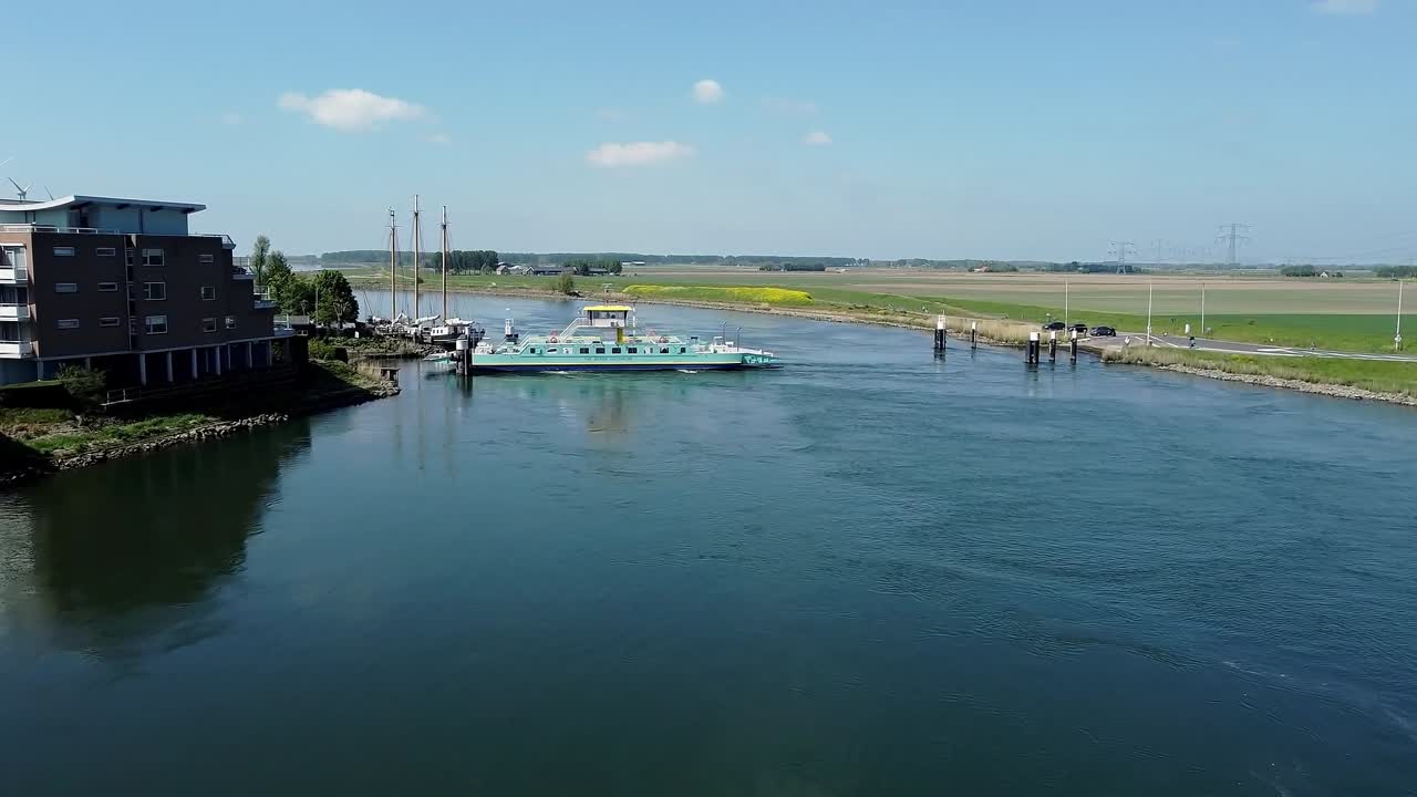 Flying with a drone over a river towards a ferry in Holland.