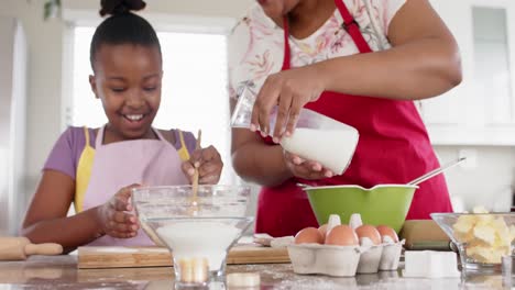 Feliz-Madre-E-Hija-Afroamericanas-Inalteradas-Horneando-En-La-Cocina,-En-Cámara-Lenta