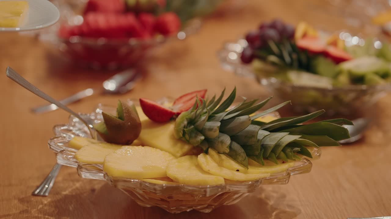 pineapple slices served in glass bowl with fork on wooden table