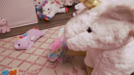 rocking unicorn in messy little girl's room with stuffed animals childhood