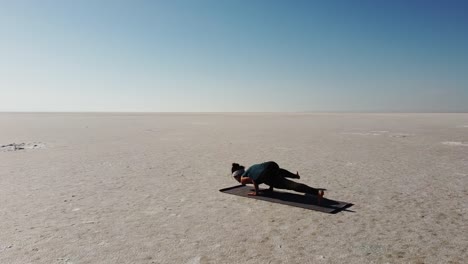 beautiful girl practicing vinyasa yoga in a wild landscape