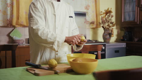 assistant chef in uniform peels potatoes before a service in an italian kitchen