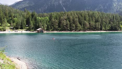 family enjoy watersport stand up paddle in lake in tyrol austria