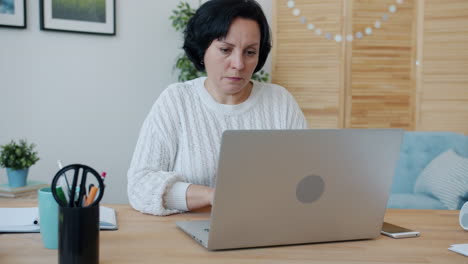 mujer trabajando desde casa en una computadora portátil