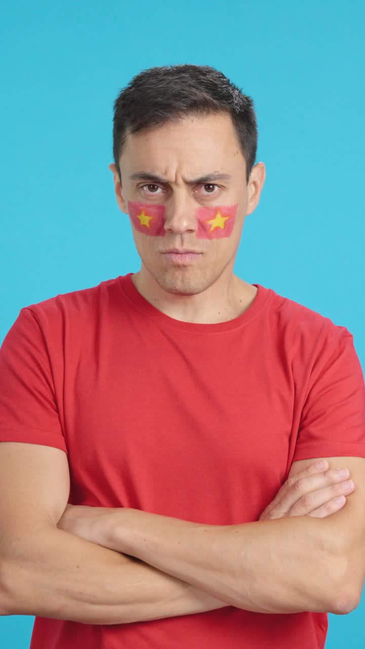 Dignified and serious man with vietnamese flag painted on face