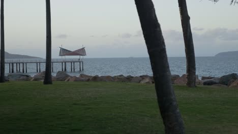 Vista-De-Un-Embarcadero-Desde-La-Tierra-Rodeada-De-Agua-Con-Islas-En-El-Fondo