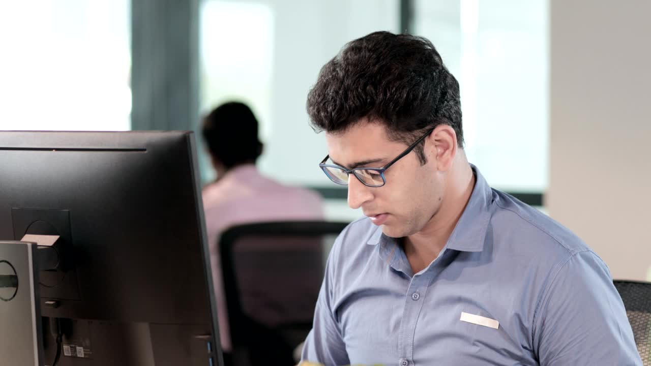 un apuesto y atractivo joven miembro del personal que usa gafas enfocado y trabajando duro