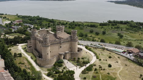 Punto-De-Vista-Aéreo-Sobre-El-Castillo-De-Mendoza-En-Manzanares-El-Real---Espectacular-Lago-Y-Paisaje-De-Fondo