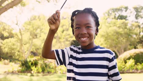 Happy-boy-waving-American-Flag-at-park