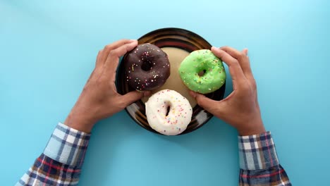 tres rosquillas de colores en un plato