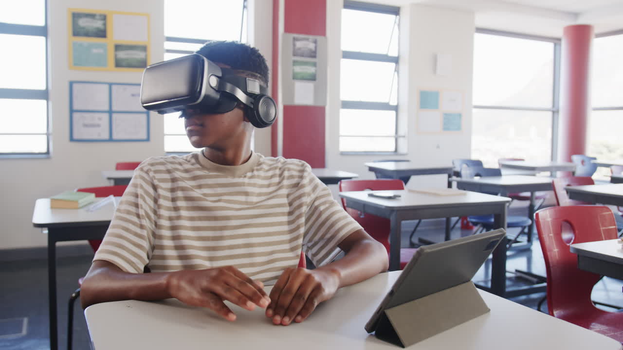 Using VR headset, boy interacting with tablet in school classroom