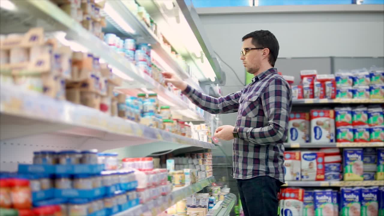 hombre comprando comida para bebés en una tienda de comestibles