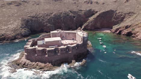 low angle aerial orbit of fort of the berlengas, above turquoise water