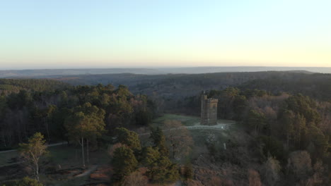 Smooth-aerial-drone-shot-circling-Leith-Hill-tower-in-the-Surrey-Hills,-in-the-English-countryside