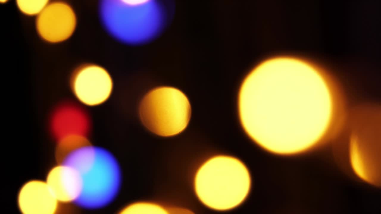 Abstract bokeh background in motion. shining, blurred multicolored particles, lights. bright bokeh from garlands on dark background. New year or Christmas festive backdrop