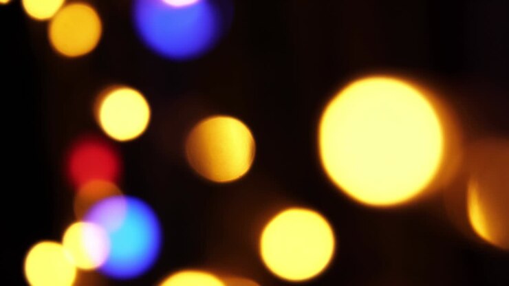 Abstract bokeh background in motion. shining, blurred multicolored particles, lights. bright bokeh from garlands on dark background. New year or Christmas festive backdrop