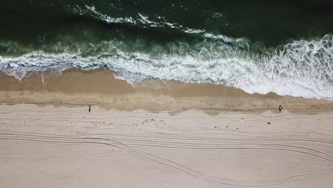 top down aerial shot of foamy green waves of half moon bay beach fly up