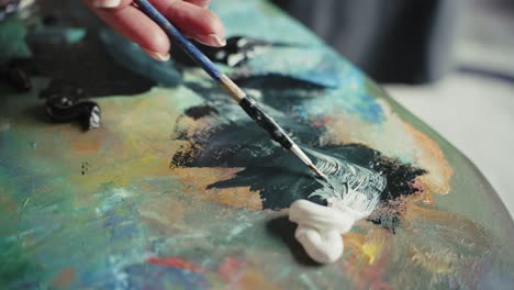 artista mezclando pintura en la paleta