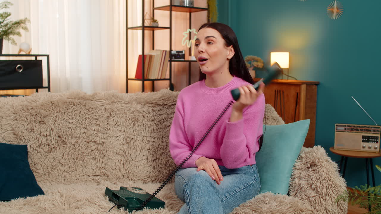 Young woman talking on retro 90s telephone making funny faces unwilling annoyed conversation mood