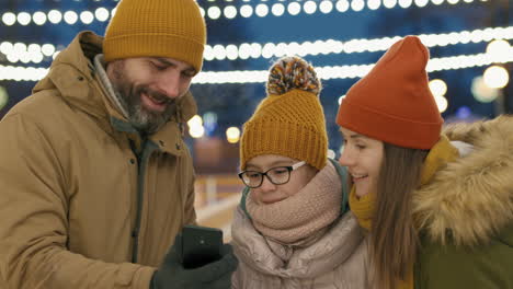 family taking selfie at ice rink