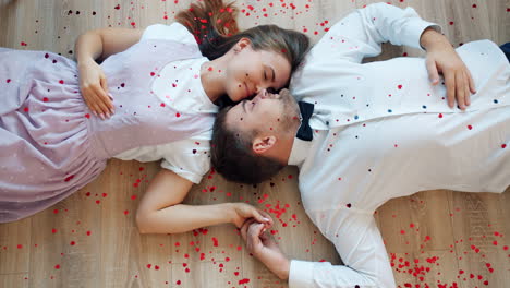 couple lying down on the floor with hearts