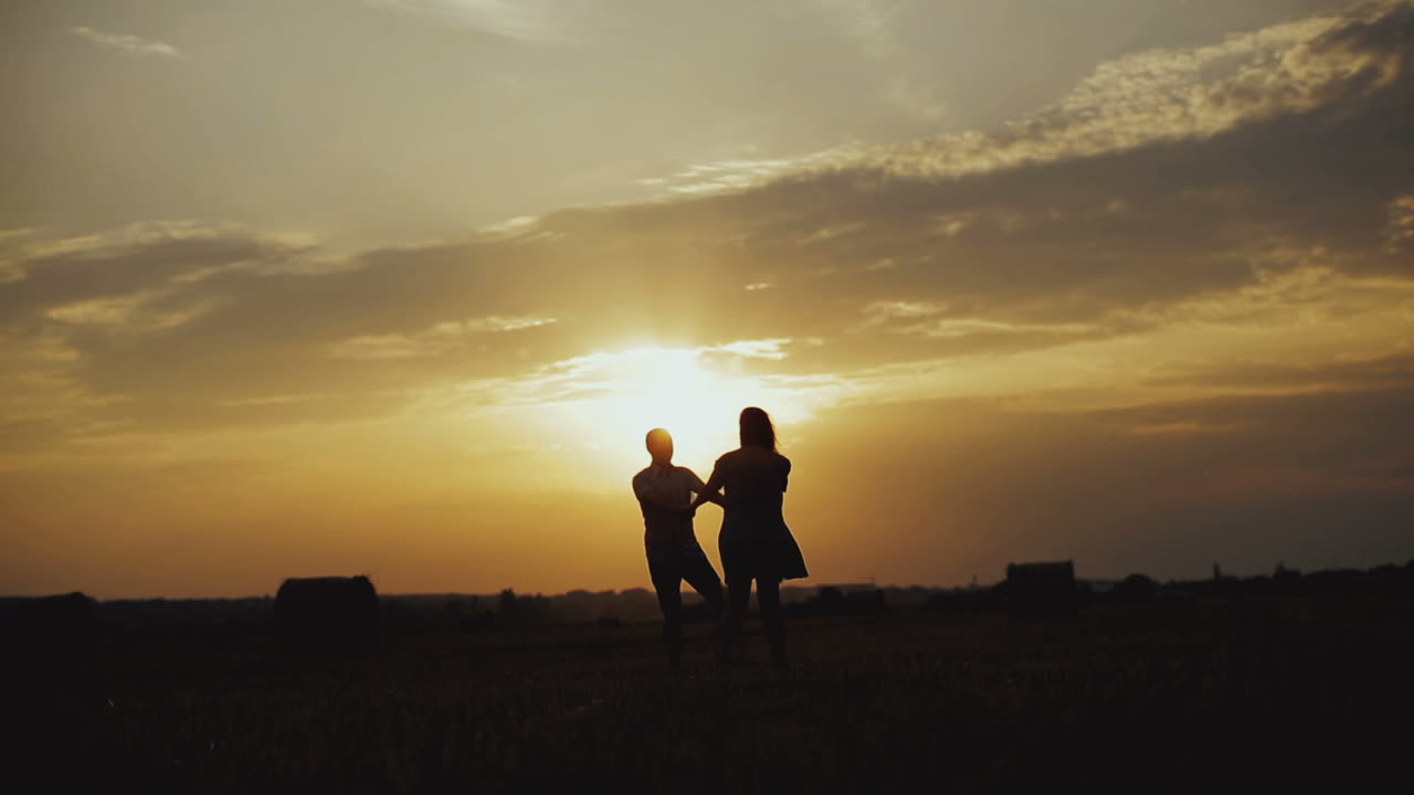 Romantic couple at sunset. Young couple enjoying the sunset in the meadow