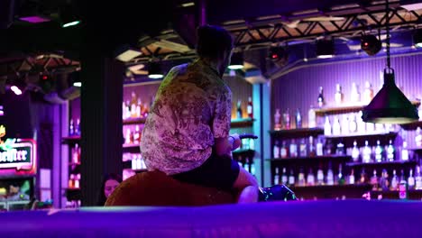 man rides mechanical bull in vibrant bar