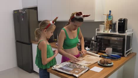 madre y hija horneando galletas de navidad