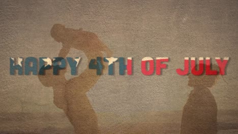 independence day text against silhouette of father carrying his child