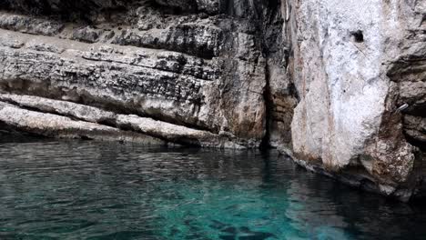 rock wall and turquoise waters in the green cave in vis island, croatia