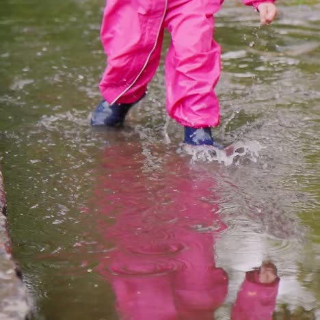 a cheerful girl jumps through puddles in the park 1