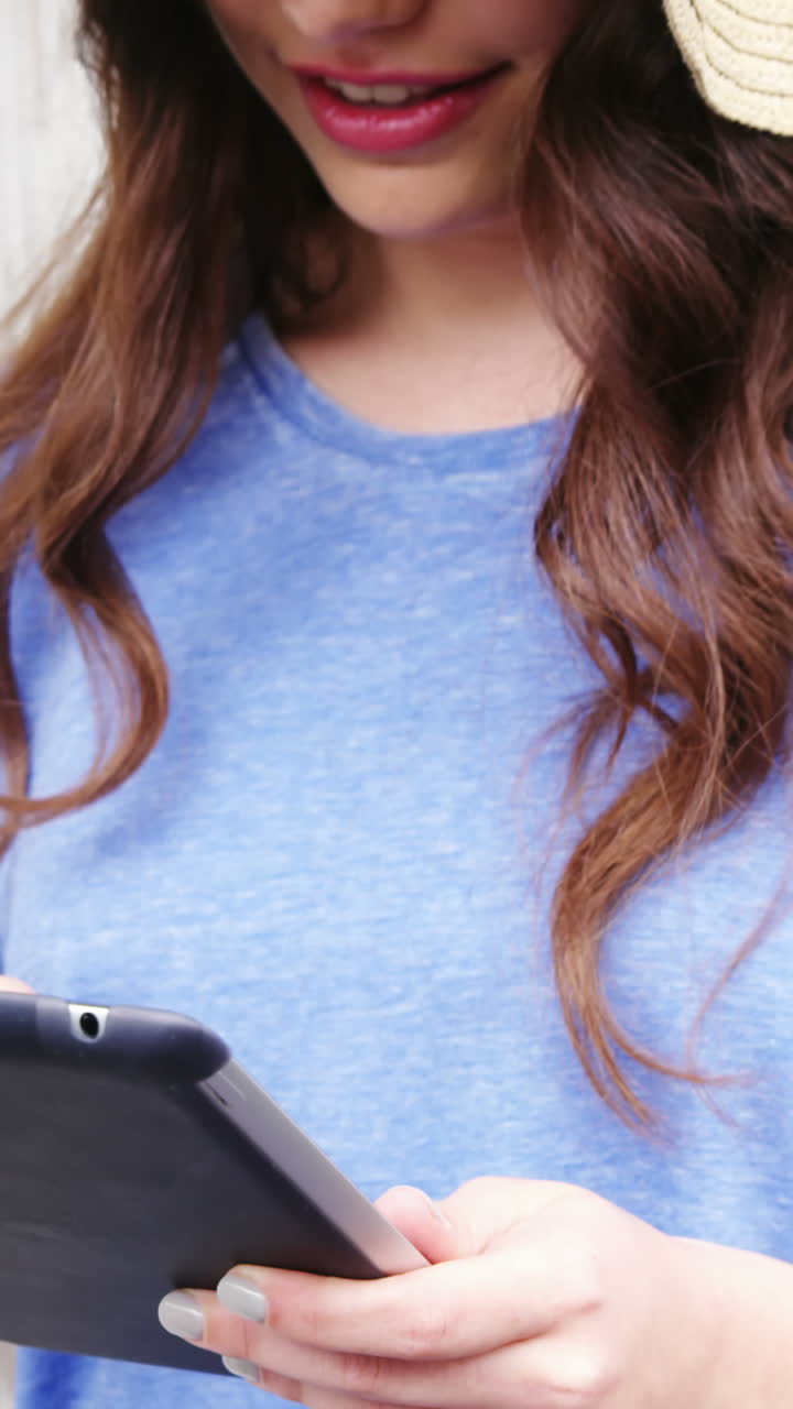 hermosa mujer con sombrero usando una tableta digital