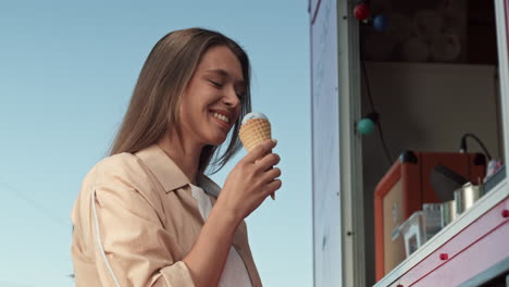 young woman eating icecream by foodtruck