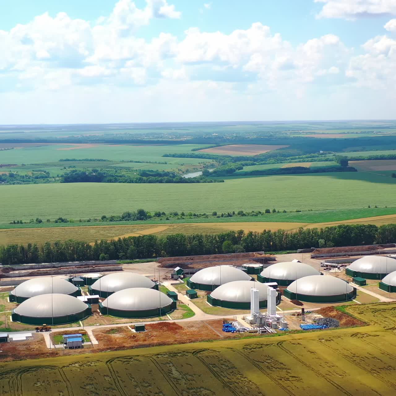 Flight around biogas power plant. Aerial drone footage of biogas plant at countryside