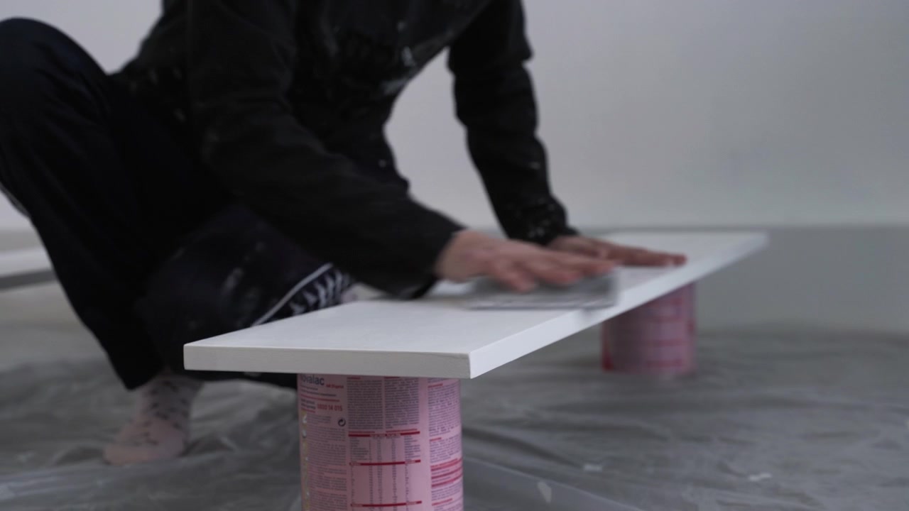 Girl sanding a wooden board before painting.
