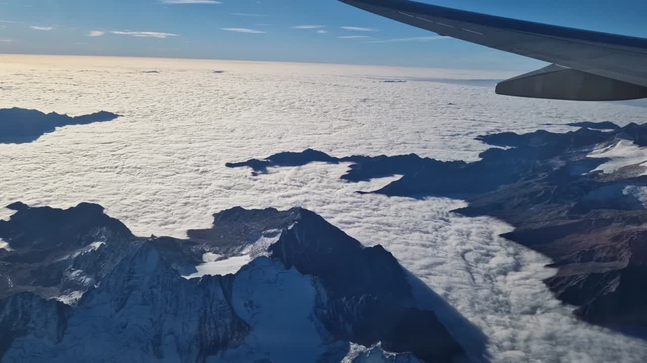 vista de ala de avión y majestuosos alpes nublados y nublados
