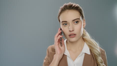 una mujer de negocios seria hablando por teléfono móvil.