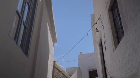 reveal of typical white greek houses and sky behind arch