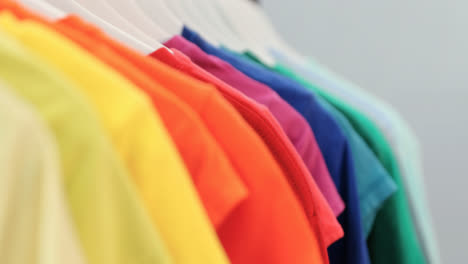 various t-shirts arranged in a row on cloth rack 4k