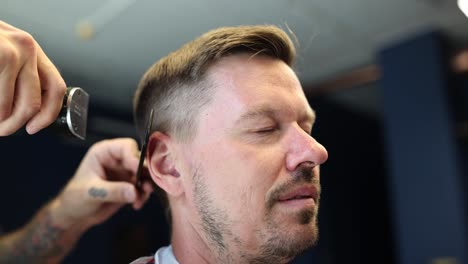 un hombre se corta el cabello en una barbería.